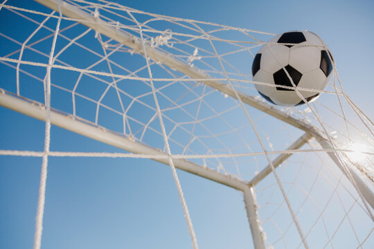 soccer ball in the net on the blue sky background