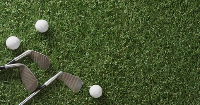Close up of golf clubs and balls on grass, copy space, slow motion