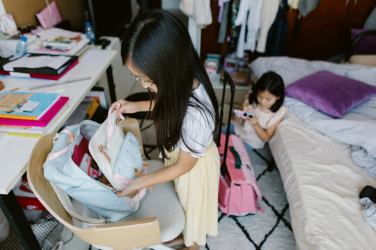 Two girls  packing their schoolbags at home