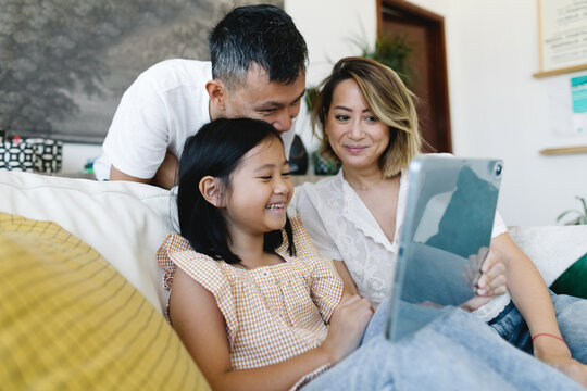 A family watching a video on a tablet computer at home