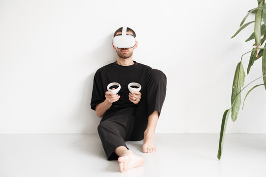 Man using virtual reality headset and joysticks