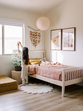 Girl Decorating Mini Christmas Tree In Bedroom