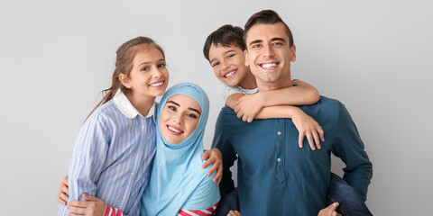 Portrait of happy Muslim family on light background