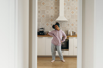 Content girl enjoying music in headphones at home