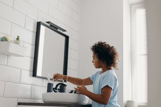 Black kid brushing teeth in morning
