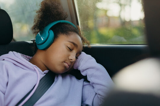 Sleepy black girl in car on way to school
