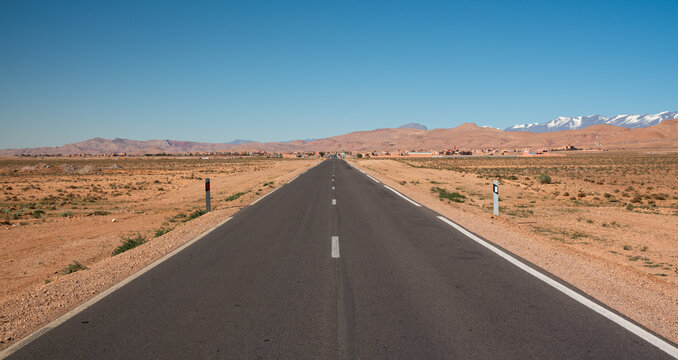 Road to little village in Morocco, atlas mountains in the background.