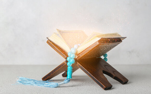 Muslim tasbih and Quran book on light background
