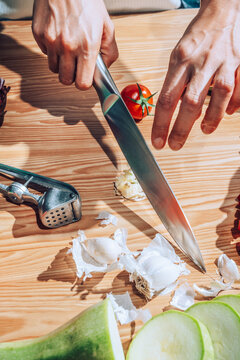 Chef slicing garlic with knife