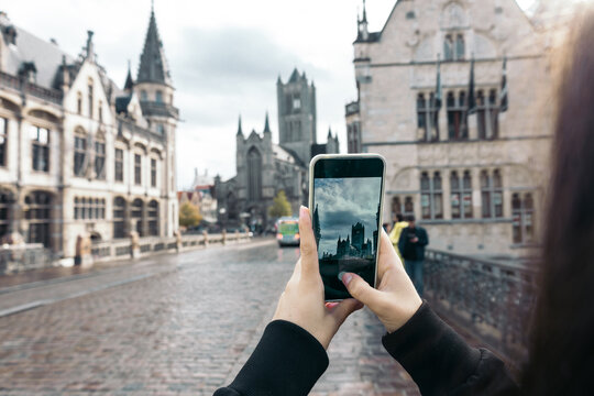 Taking photos with smartphone to the church of St. Nicholas, Ghent