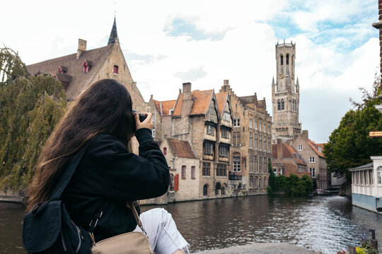 Woman taking photos with camera in Bruges, Belgium