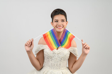 Young asian beautiful bride with rainbow flag on white background