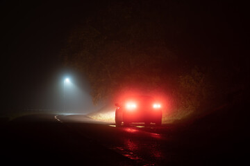 A car parked by a street light at night