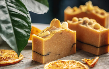 Natural soap and slices of oranges on the wooden table. Concept of making and using organic eco soap and cosmetics
