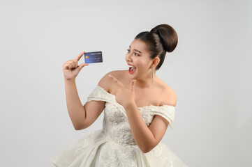Young asian beautiful bride posting with credit card in hand
