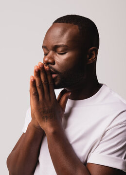 Elegant black man with white t-shirt suit praying