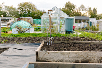 Allotment garden with garden fork stuck in soil