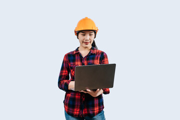 Young female engineer wearing Yellow helmet and use laptop computer