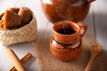 Cafe de Olla. Traditional Mexican coffee and basic ingredients for its preparation, coffee, cinnamon and piloncillo, served in a clay cup called 