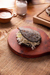 Gordita de Chicharron. Blue Cornmeal dough stuffed with chicharron prensado. Traditional Mexican appetizer commonly accompanied by cilantro, onion and hot sauce.