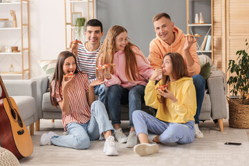 Group of friends eating tasty pizza in living room