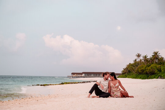Couple walking alongside Maldive beach