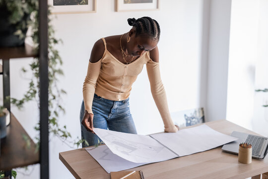 Black architect working in sunlit workspace