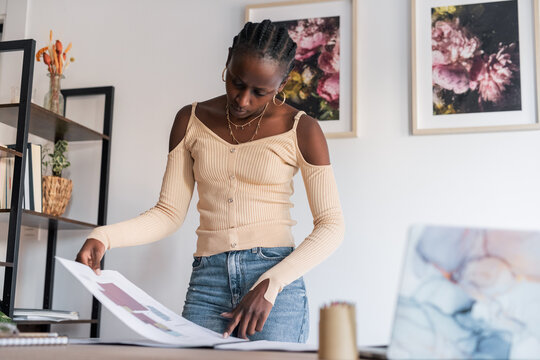 Black architect examining draft in album