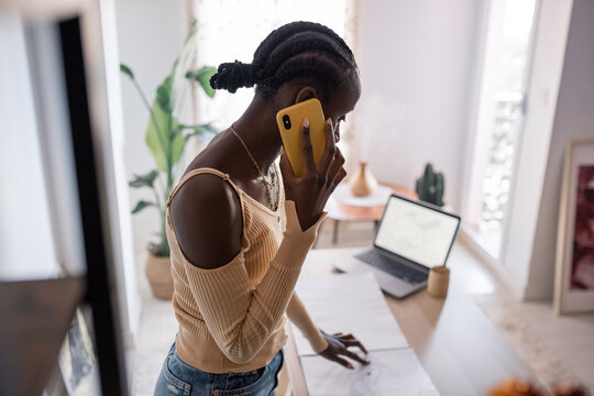 Black architect talking on smartphone during work