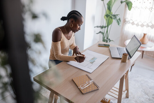 Black architect working in sunlit workspace