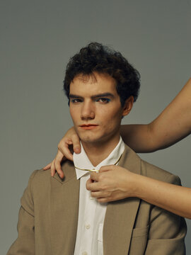 Assistant fixing model's outfit in studio portrait