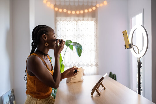 Glad beauty blogger applying rouge