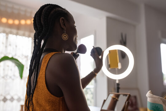 African American vlogger showing powder and brush