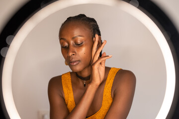 African American blogger touching face gently