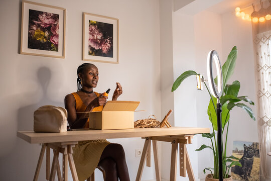 Black influencer opening bottle of lotion