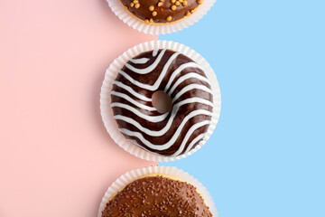 Delicious chocolate donuts on color background, closeup