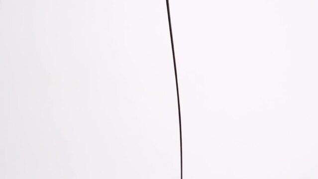 Hershey's Chocolate syrup ice cream dessert topping drizzling and dropping in slow motion on white backdrop