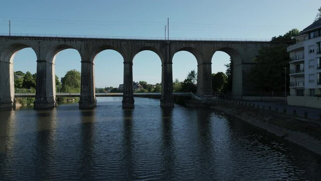 Drone flying over the Mayenne Laval River, France. Arches of the railway bridge