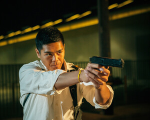 A man dressed as a detective / policeman aims his gun.