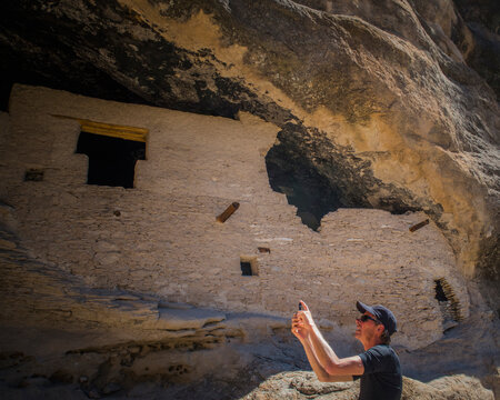Man photographing cliff dwellings, Central New Mexico, New Mexico, USA