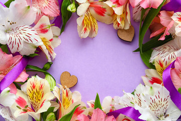 Wreath made of beautiful alstroemeria flowers and ribbon on lilac background, closeup. Mother's day celebration