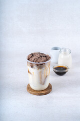 Iced chocolate milk smoothie cocktail with oatmeal on white rustic background