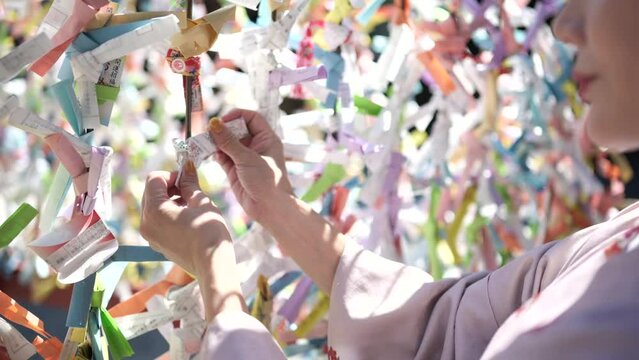 おみくじを結ぶ着物の女性の手元