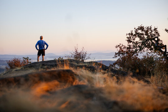 Tired runner man on top of hill after summiting.