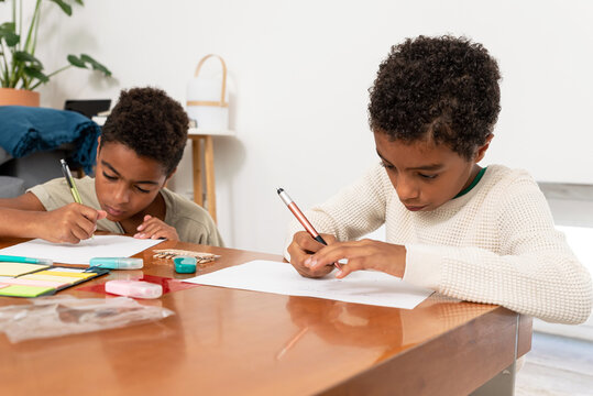 Two young boys drawing after school