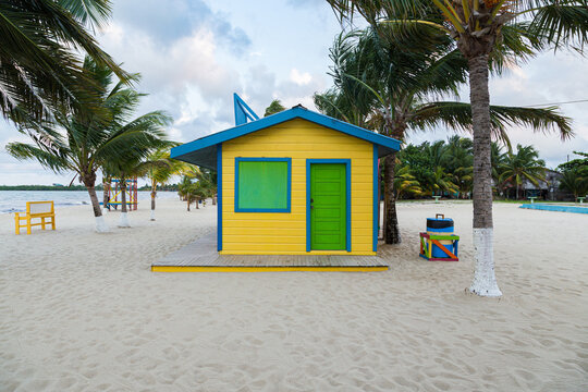 small yellow wooden room in the middle of the sand at the beach