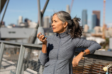 Asthmatic Woman Takes A Break From Exercise To Use Inhaler 