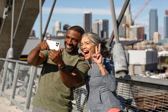 Two Friends Take A Silly Selfie On A Bridge During Morning Exercise 