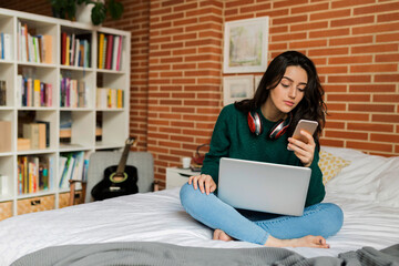 Young woman working remotely from the bed