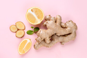 Fresh ginger roots and lemons on pink background
